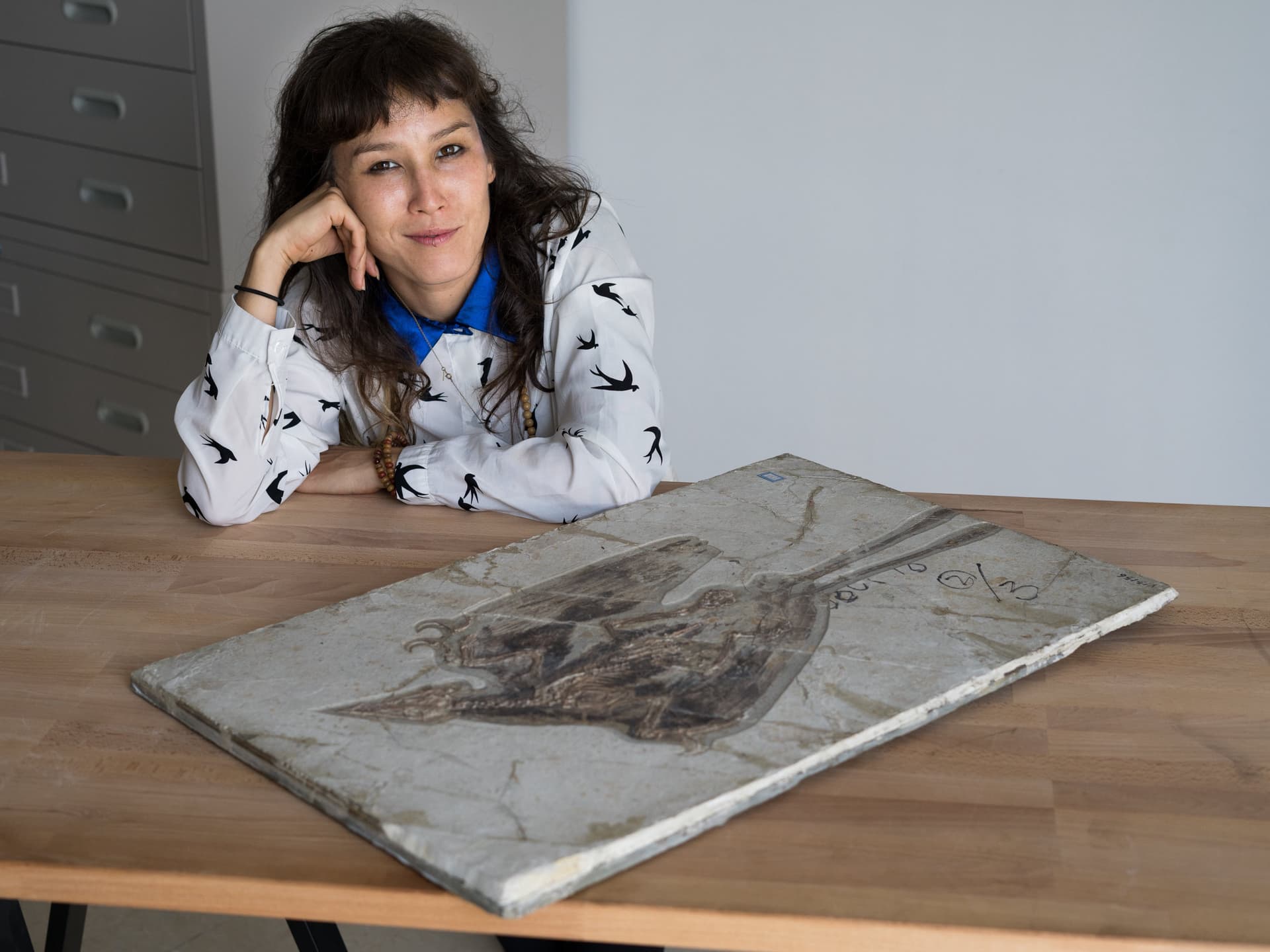 Jingmai O'Connor in front of a fossil slab